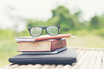 stack of books with a pair of eyeglasses on top for park