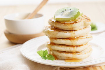 pancakes with honey syrup and fresh kiwi sliced