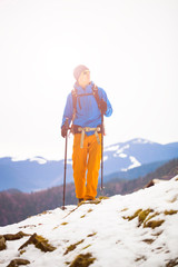 Mountain climber walks on a snowy slope.
