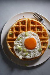 warm waffle with fried egg for breakfast.