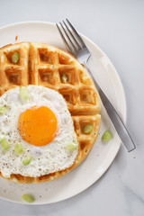 warm waffle with fried egg for breakfast.