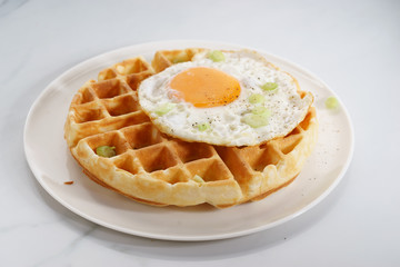 warm waffle with fried egg for breakfast.