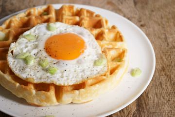 warm waffle with fried egg for breakfast.
