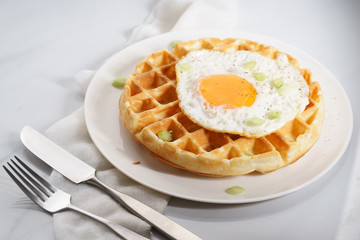 warm waffle with fried egg for breakfast.