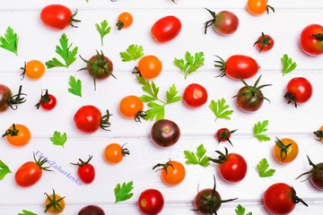 Colorful bright pattern of multi-colored leaves of parsley and cherry tomatoes. Cooking concept.