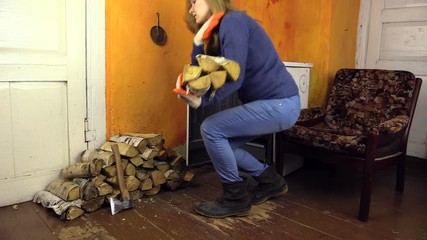girl with orange gloves bring firewood to stove in sitting room