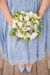 Obraz na płótnie Canvas Top view on woman in blue dress holding beautiful wedding bouquet of flowers. Bride.