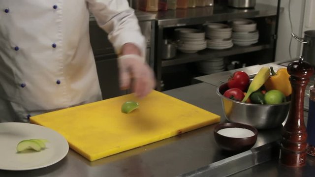 Chef putting carved apple on a plate