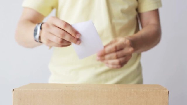 man putting his vote into ballot box on election