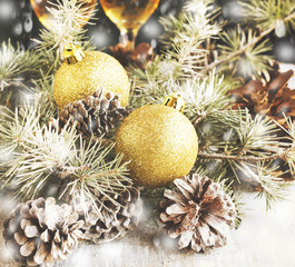 Christmas balls with fir branches and glasses of champagne