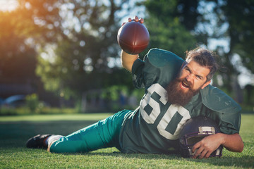 Brutal man with a long beard and mustache in the shape of an American football player with helmet...