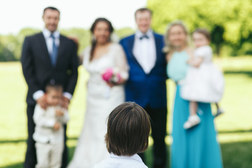 Obraz premium Little boy looks at the people posing for family picture