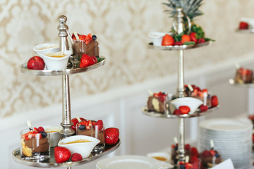 Chocolate sweets and strawberries stand on different layers of t