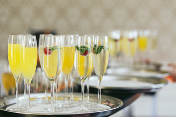 Steel trays with champagne flutes stand on the table