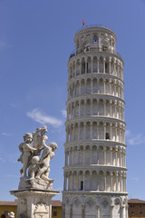 Fototapeta na wymiar Statue the cherubim of the fountain dei putti with the famous leaning Tower of Pisa in Italy