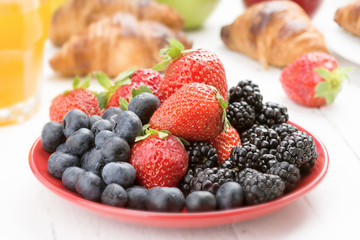 ripe berries and croissants on wood, selective focus