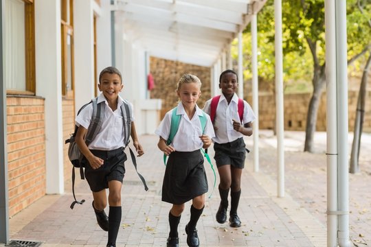 Smiling School Kids Running In Corridor