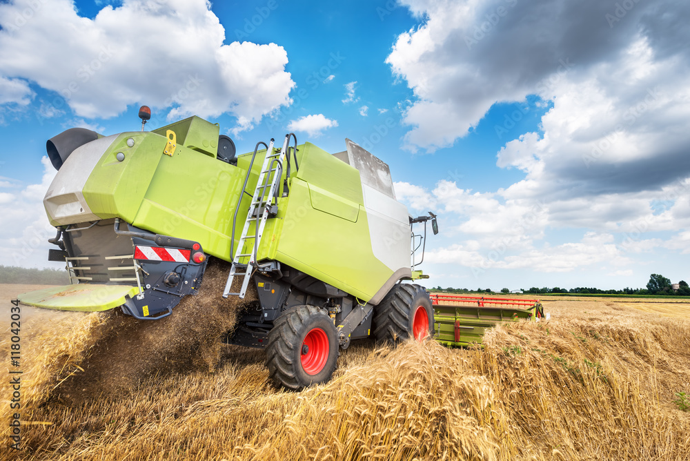 Poster combine harvester working on a wheat field.