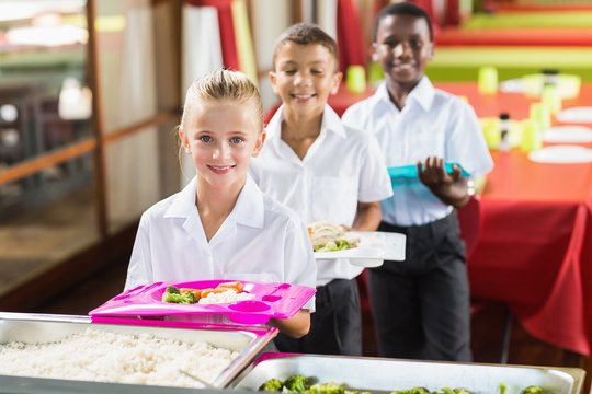 Portrait of school kids having lunch during break time 