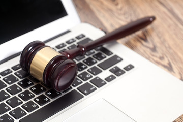 Judge gavel with laptop computer on wooden background © yurchello108