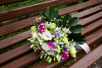 Fototapeta na wymiar Beautiful bridal bouquet of flowers on wooden bench