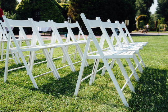 Rows Of White Folding Chairs On Lawn