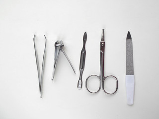 Nail file, cuticles remover,  scissors, clipper nail and tweezers on white background