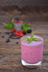 Milk shake with berries top view smoothie with mint on a rustic table