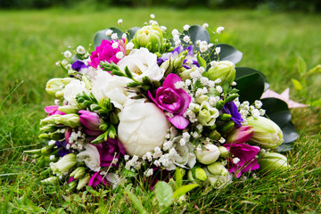 Beautiful bridal bouquet of flowers on green lawn