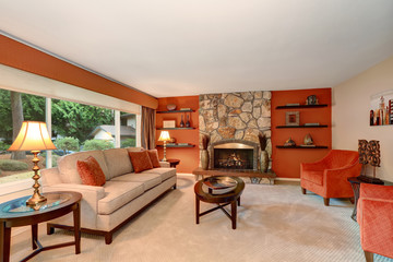 Cozy family room in red tones with stone fireplace.