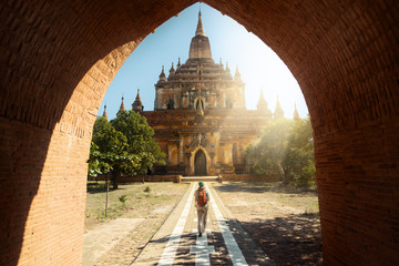 Traveler walking along road to Htilominlo temple in Bagan. Burma - obrazy, fototapety, plakaty