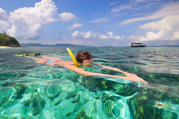 Woman snorkeling in clear tropical waters on a background of islands © soft_light