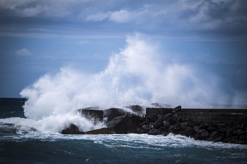 Stone breakwater with breaking waves.