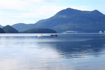 朝の洞爺湖に浮かぶカヌーと有珠山