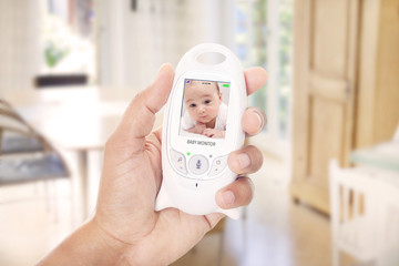 Father checking baby through baby monitor