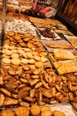 Вкусная выпечка (печенье, пончики, сладости) на прилавке в кондитерской.