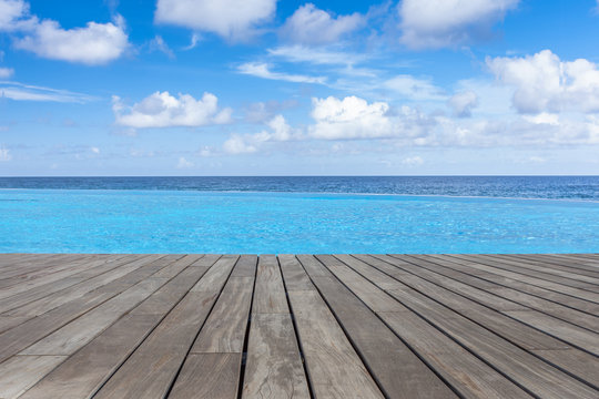 piscine à débordement margelle bois avec vue sur l'océan