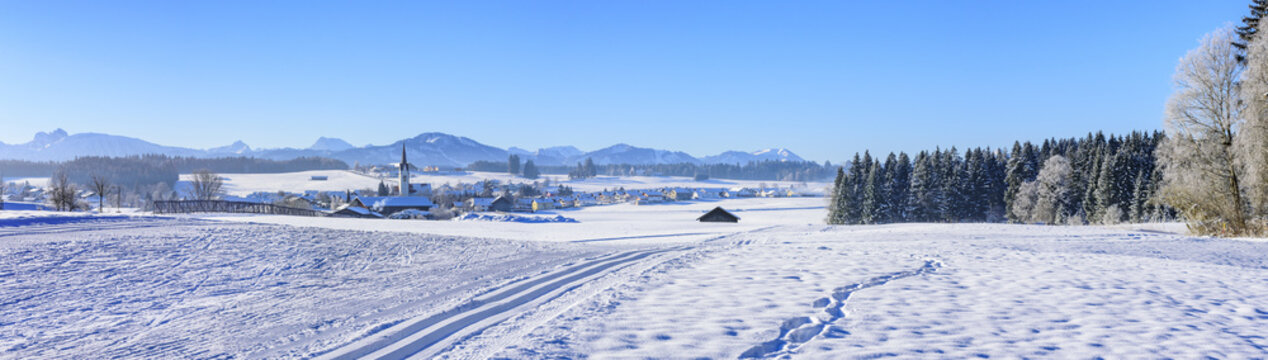 winterliches Alpenvorland mit Loipe im Vordergrund