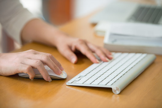 Close up of woman hands using mouse and keyboard. Working woman  click and connect at home.