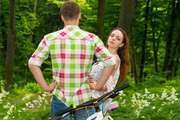 Young girl looks out from a guy and looking into the camera