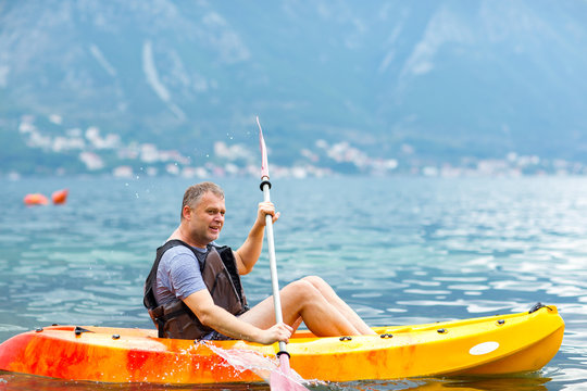 Mature Man Kayaking On The Sea