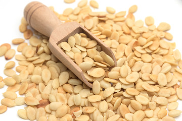 Shelled melon seeds with salt on white background