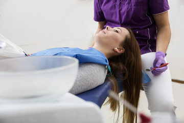 Patient Lying On Seat While Dentist Examining Her