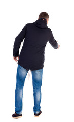 Naklejka premium man in jacket holds out his hand for handshake. Rear view people collection. backside view of person. Isolated over white background. A guy in a black jacket holding out his right hand in greeting.