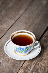 Closeup of cup of tea on vintage wooden background