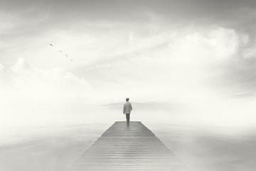 Man walking on a boardwalk in the fog