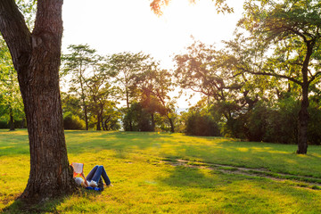 Girl reading a book in a sunny park, selective focus