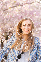 Pink petals fly around the pretty blonde