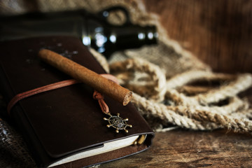 Cigar and leather notebook on a wooden background
