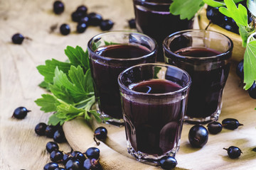 Traditional black currant liqueur in shot glass, selective focus